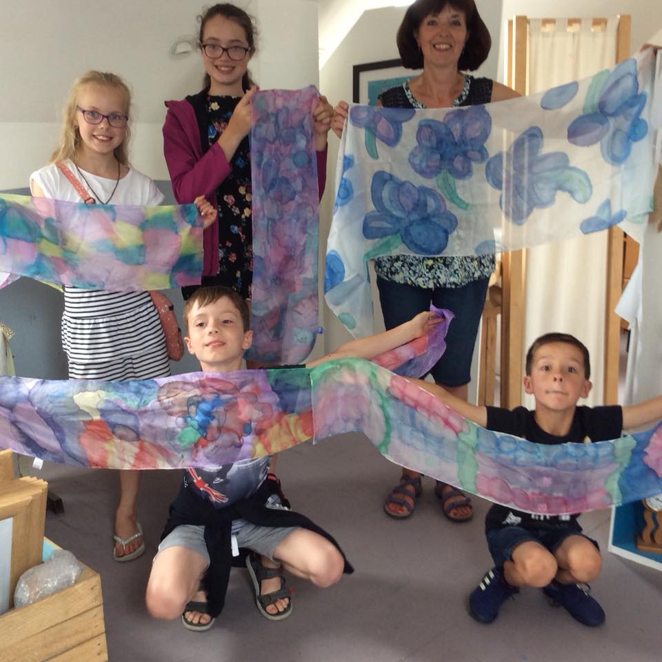 Family holding up their painted silk scarves